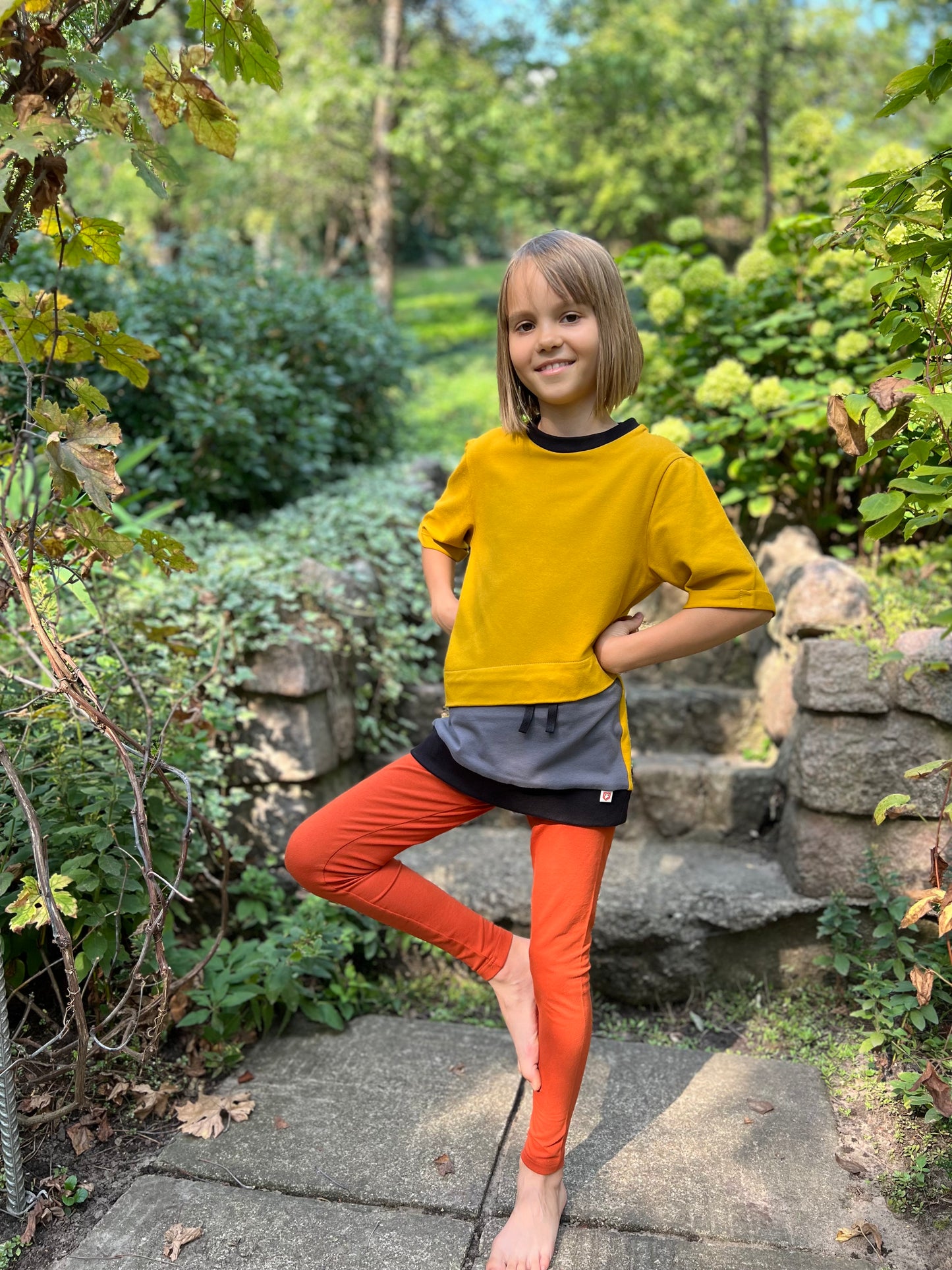Orange leggings for kids with Type 1 diabetes, featuring discreet insulin pump pockets for convenient and comfortable wear. Stylish and functional design.